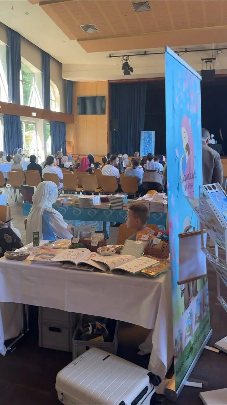 Stand mit islamischen Kinderbüchern und Lernmaterialien, im Hintergrund das Publikum