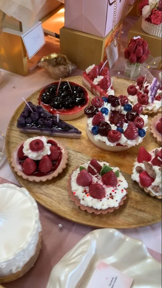 Törtchen und Kuchen mit frischen Beeren auf einem Holzbrett
