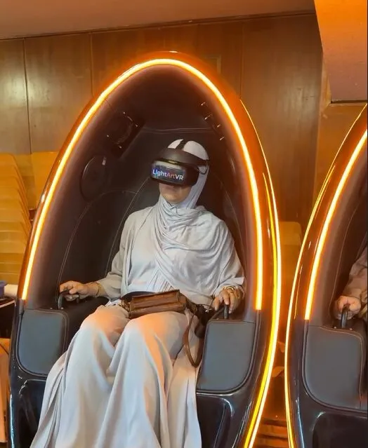 Besucherin mit VR-Brille in einer beleuchteten Sitzecke