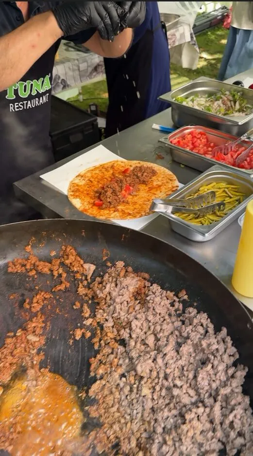 Warmes Essen wird in großen Pfannen zubereitet