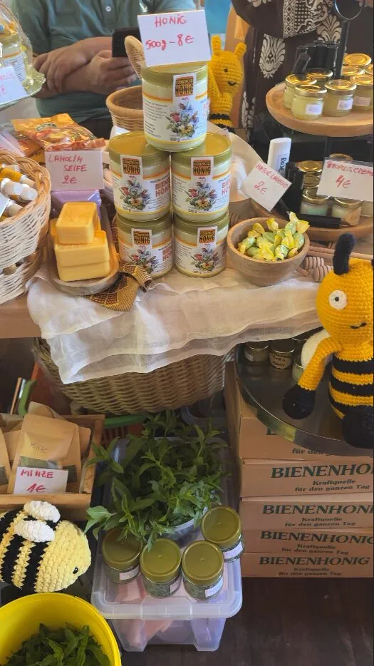 Stand mit Honiggläsern und Bienen-Dekoration